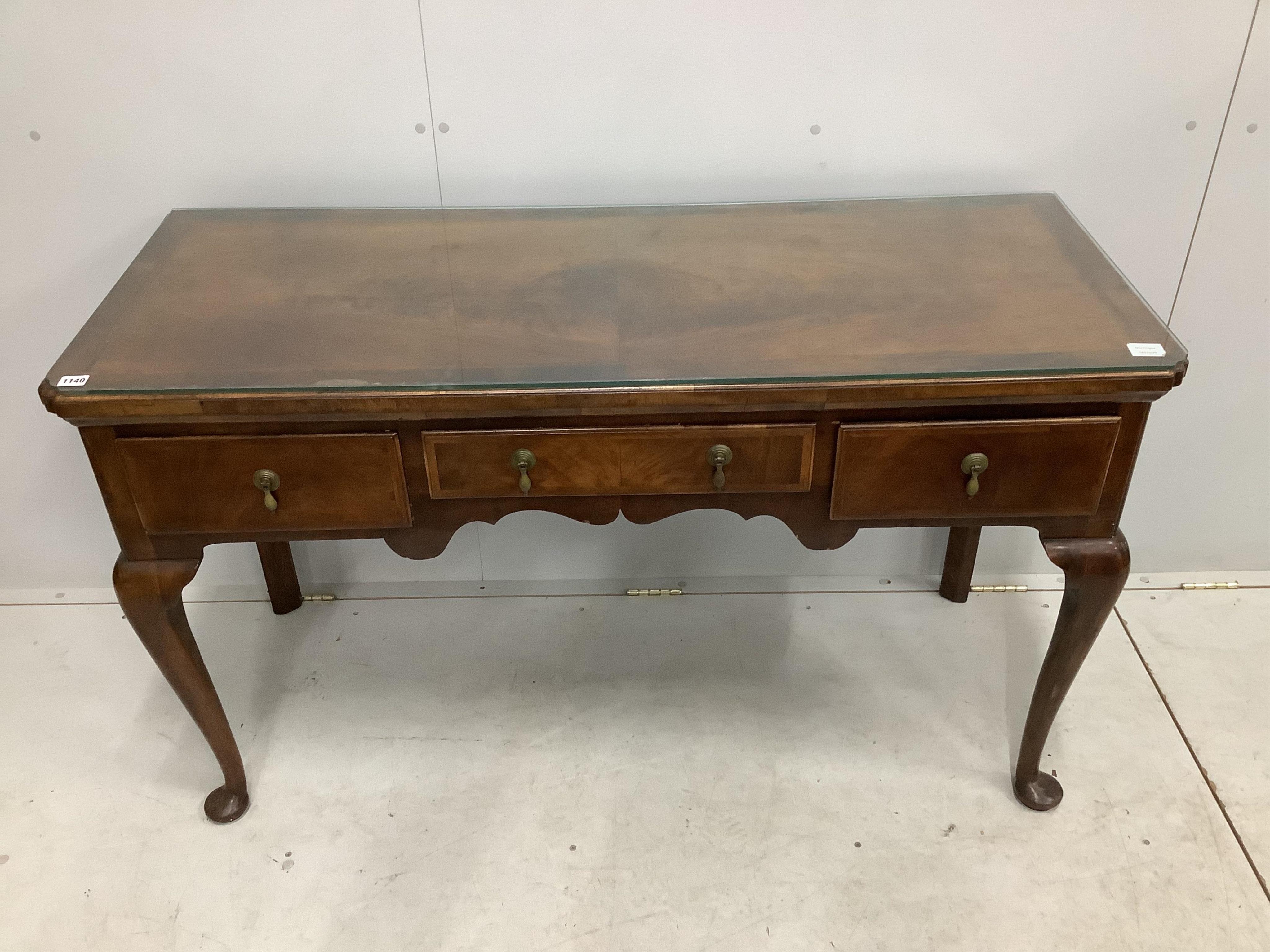 A George II style feather and cross banded walnut three drawer serving table, width 136cm, depth 53cm, height 80cm. Condition - fair